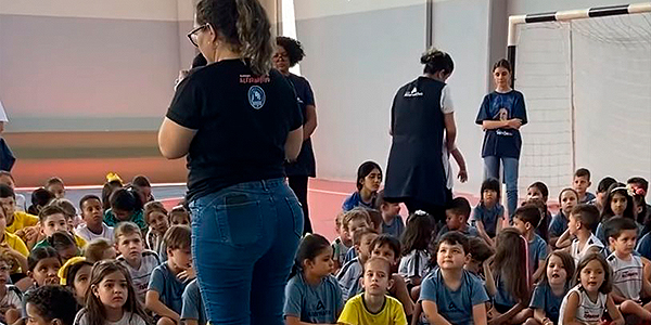 Alunos sentados vendo apresentações da semana da pátria