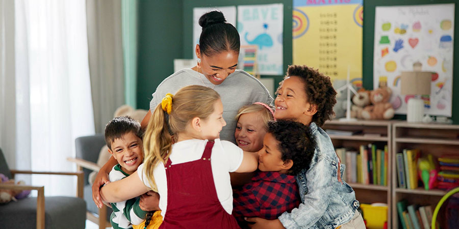 professora abraçando alunos 