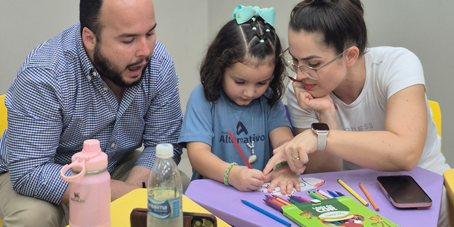 Pais fazendo atividades com a filha na escola