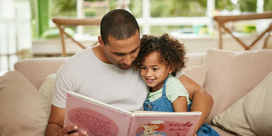 pai lendo livro para filha 
