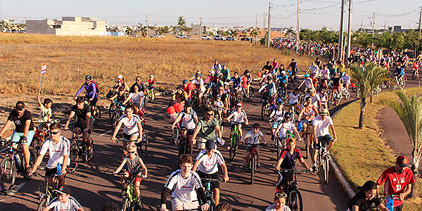 Alunos e pais andando de bicicleta no passeio ciclístico do Colégio Alternativo 