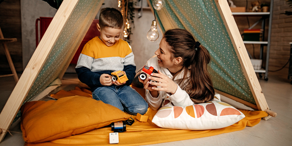 Mãe e filho brincam de acampamento seguindo dicas de férias do Colégio Alternativo