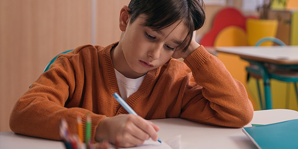 Menino triste estudando porque não tem dificuldade com matemática. 