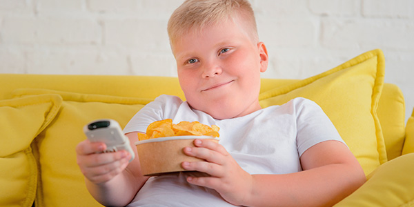 Menino comendo pipoca com estilo sedentário