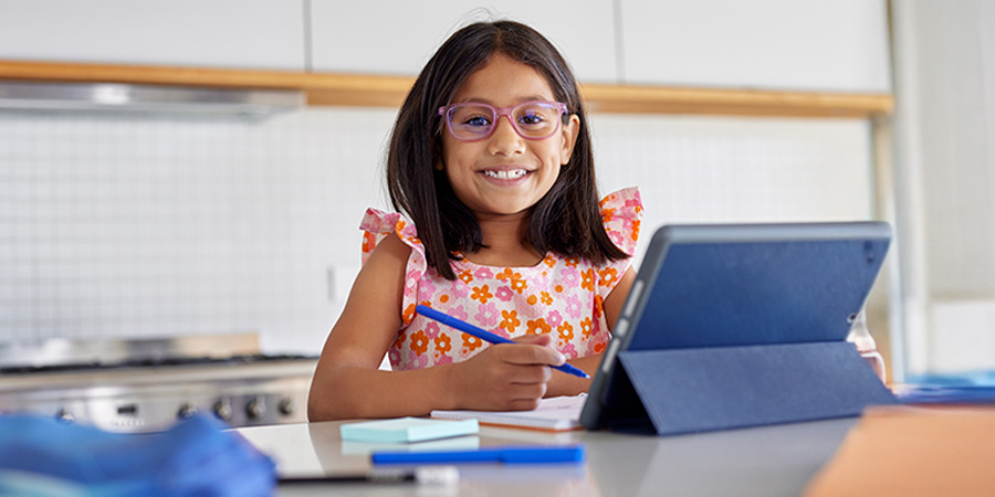 menina sorrindo estudando - Sinais de inteligência acima da média e superdotação na infância
